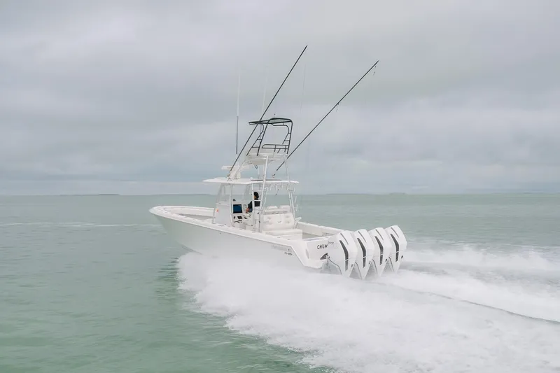 Slide: The Image of 2023 Contender 39 ST boat speeding on open water with multiple outboard engines. - 2