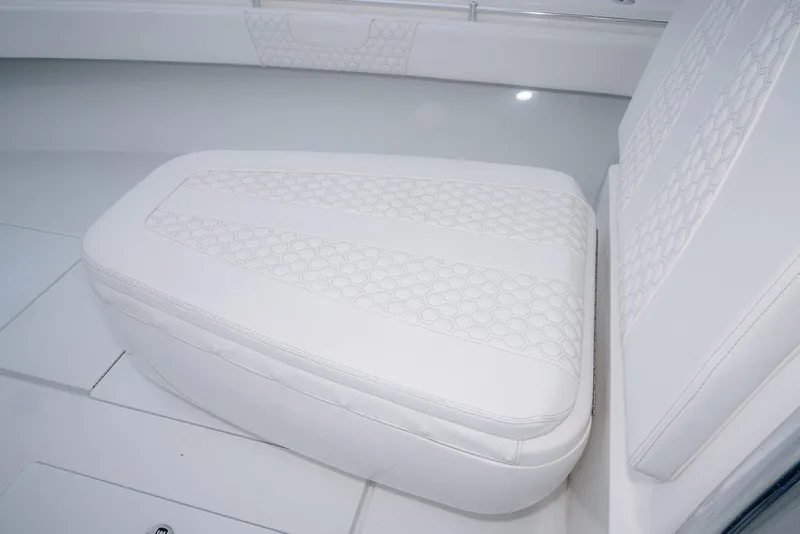 Slide: The Image of 2023 Contender 39 ST boat interior with white cushioned seating and hexagonal stitching. - 22