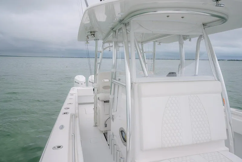 Slide: The Image of 2023 Contender 39 ST boat on calm waters, showcasing sleek design and spacious deck. - 28