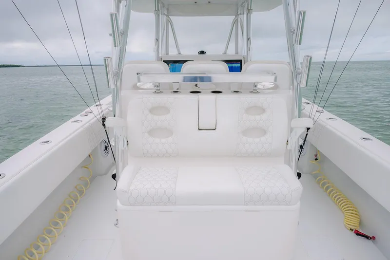 Slide: The Image of 2023 Contender 39 ST boat interior with white seating and fishing rod holders. - 32