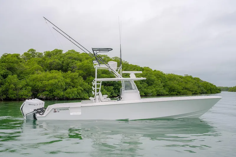 Slide: The Image of 2023 Contender 39 ST boat on calm water, surrounded by lush greenery. - 7