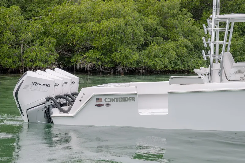 Slide: The Image of 2023 Contender 39 ST boat with triple Racing 300 engines in a serene water setting. - 8