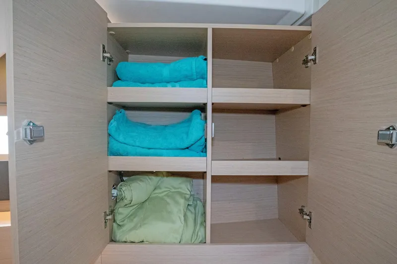 Slide: The Image of Open cabinet with folded towels on Beneteau Oceanis 461 yacht, 2022 model. - 12