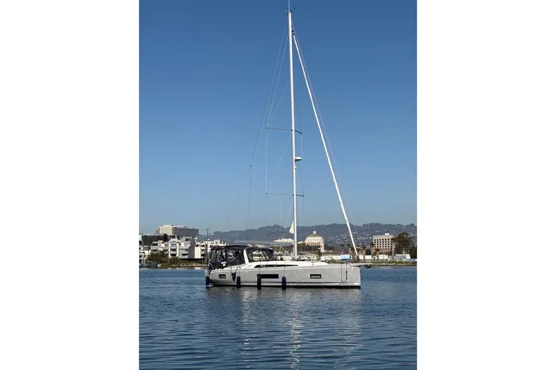Slide: The Image of 2022 Beneteau Oceanis 461 sailboat on calm water with cityscape background. - 2