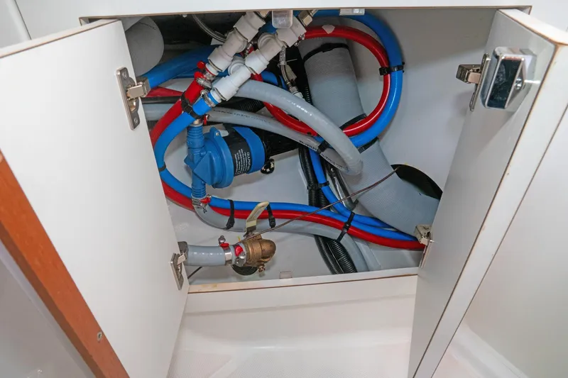 Slide: The Image of Plumbing system inside a 2022 Beneteau Oceanis 461 yacht, featuring colorful pipes and fittings. - 33