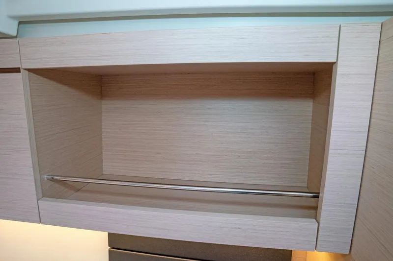 Slide: The Image of Empty wooden cabinet with metal bar inside Beneteau Oceanis 461, 2022 model. - 37