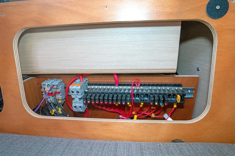 Slide: The Image of Electrical panel inside 2022 Beneteau Oceanis 461 yacht, showcasing wiring and circuit breakers. - 46