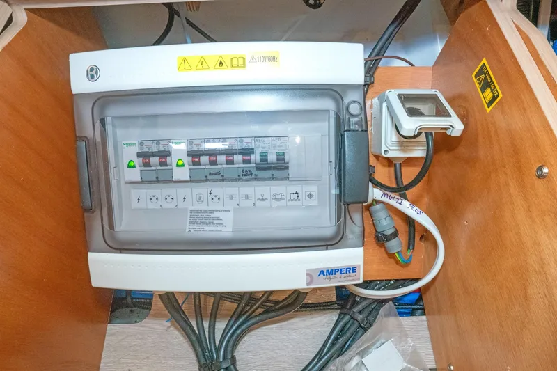Slide: The Image of Electrical panel inside 2022 Beneteau Oceanis 461 yacht, featuring circuit breakers and wiring. - 48