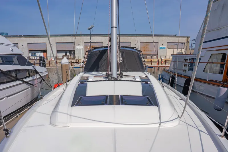 Slide: The Image of 2022 Beneteau Oceanis 461 sailboat docked at marina, showcasing sleek deck design. - 78