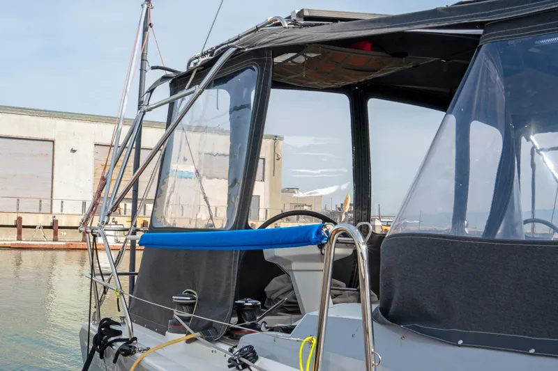 Slide: The Image of 2022 Beneteau Oceanis 461 sailboat cockpit with protective canopy in marina setting. - 79