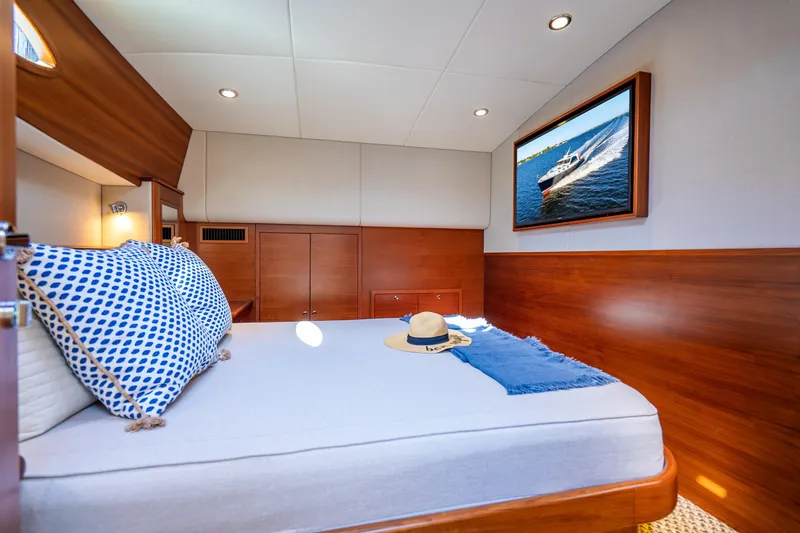 Slide: The Image of Luxurious 2020 Palm Beach Motor Yachts PB55 cabin with elegant wood finish and cozy bedding. - 21