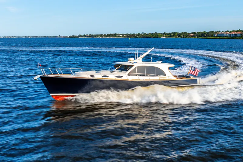Slide: The Image of 2020 Palm Beach Motor Yachts PB55 cruising on open water, creating a dynamic wake. - 5