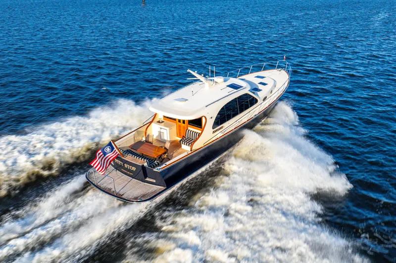 The Image of 2020 Palm Beach Motor Yachts PB55 cruising on open water, rear view. - 0