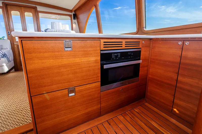 Slide: The Image of 2020 Palm Beach Motor Yachts PB55 interior with wooden cabinetry and modern oven. - 13