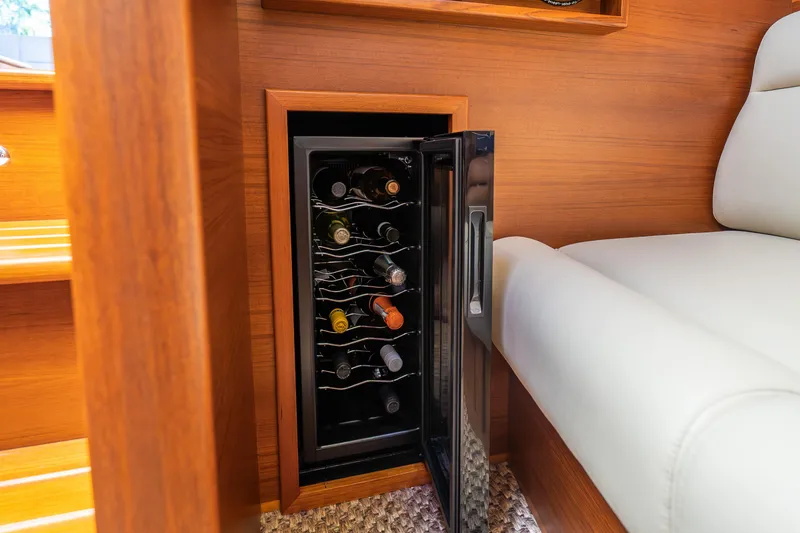 Slide: The Image of Luxury yacht PB55 interior with wine cooler, wooden finish, and white seating, 2020 model. - 19