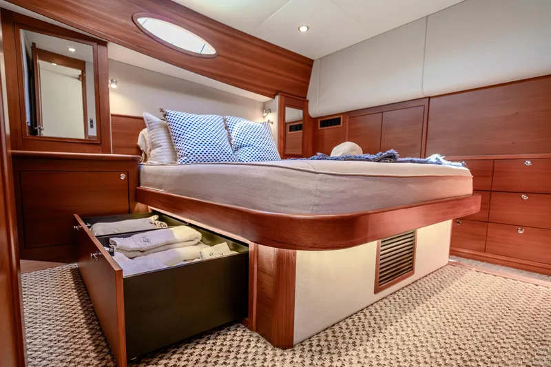 Slide: The Image of Luxurious 2020 Palm Beach Motor Yachts PB55 bedroom with elegant wood finish and under-bed storage. - 24