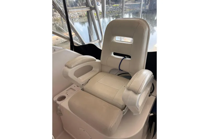 Slide: The Image of Captain's chair on 2006 Pro-Line 32 Express boat, featuring cushioned armrests and cup holder. - 10