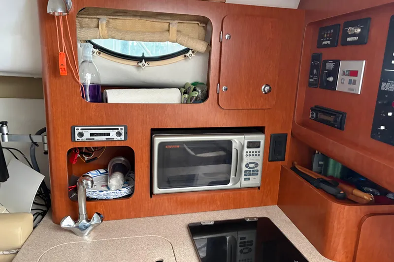 Slide: The Image of 2006 Pro-Line 32 Express boat interior with microwave, sink, and control panels. - 13
