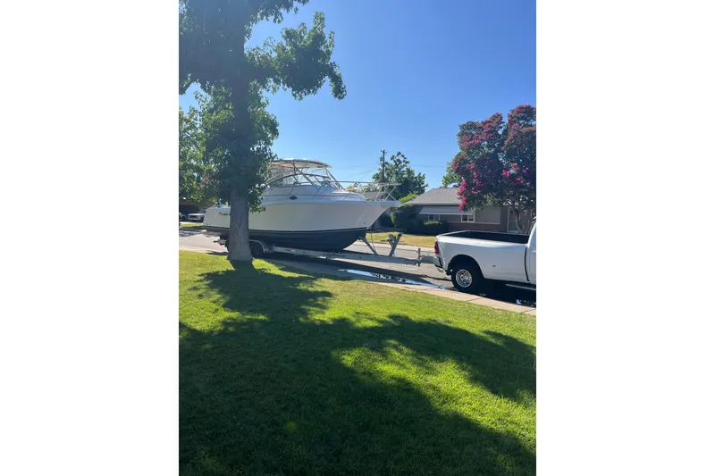 Slide: The Image of 2006 Pro-Line 32 Express boat on trailer, parked in a suburban neighborhood. - 18