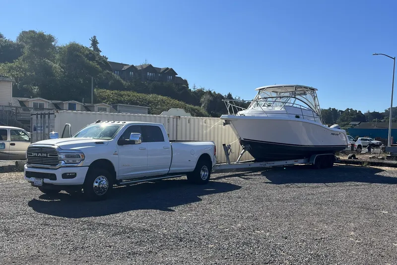 Slide: The Image of White 2006 Pro-Line 32 Express boat on trailer, towed by a white Ram truck. - 2