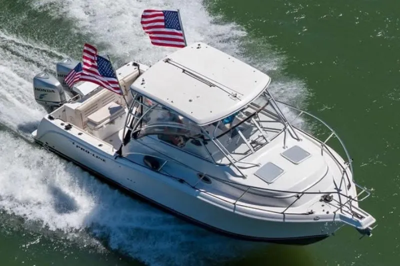 Slide: The Image of 2006 Pro-Line 32 Express boat cruising with American flags on a sunny day. - 3