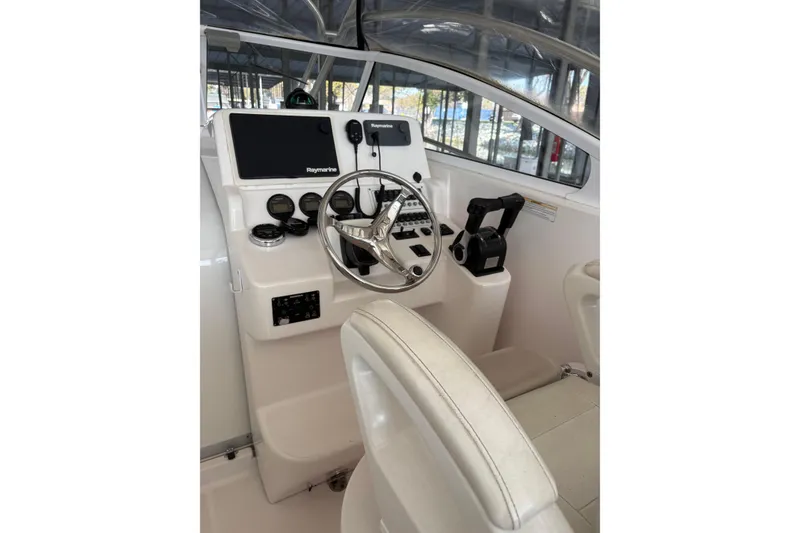 Slide: The Image of 2006 Pro-Line 32 Express boat helm with steering wheel and navigation controls. - 9