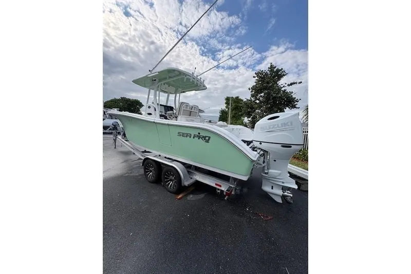Slide: The Image of 2023 Sea Pro 259 DLX boat on trailer with Suzuki outboard motor. - 2