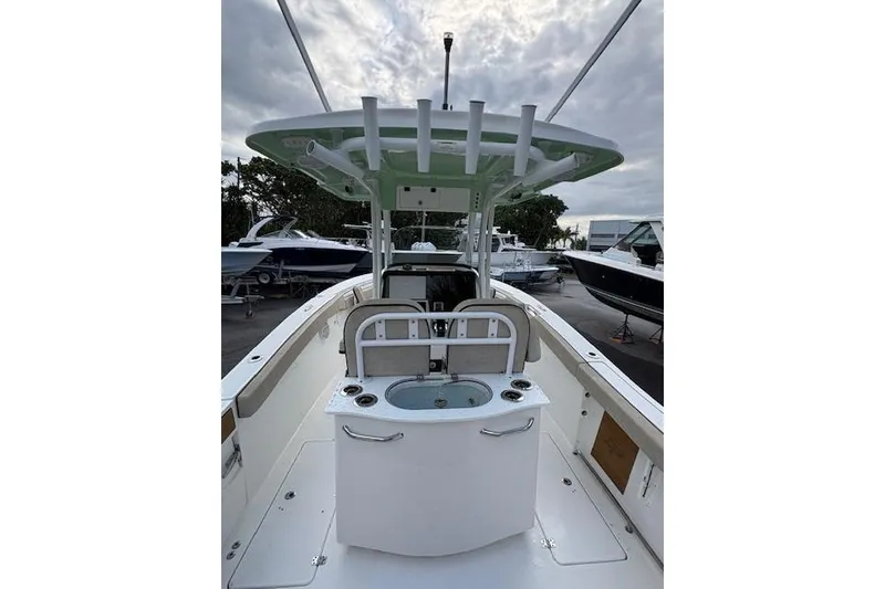 Slide: The Image of 2023 Sea Pro 259 DLX boat interior with center console and rod holders. - 3
