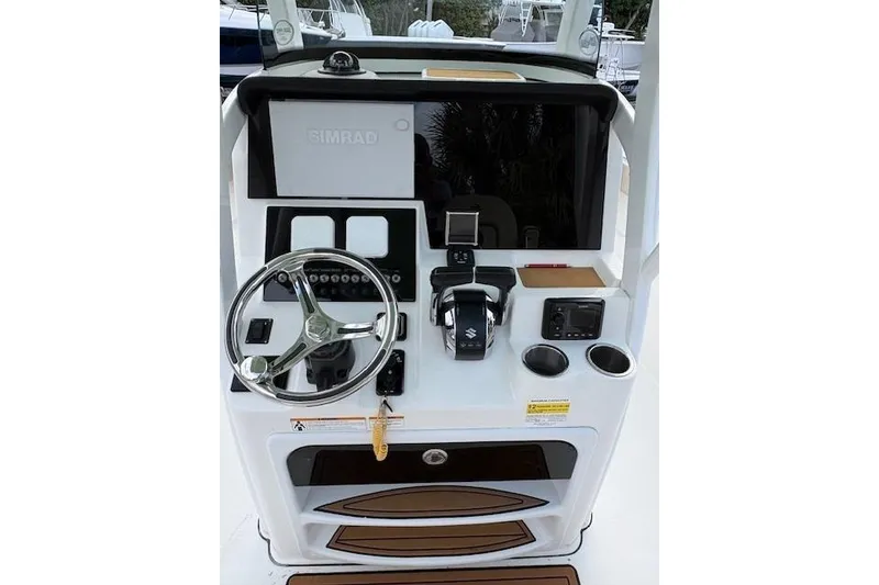 Slide: The Image of 2023 Sea Pro 259 DLX boat console with steering wheel and navigation controls. - 4