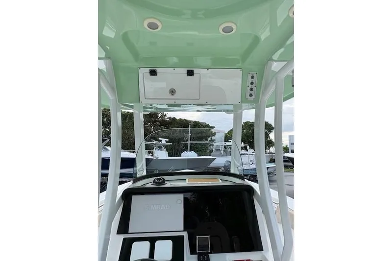 Slide: The Image of 2023 Sea Pro 259 DLX boat console with green canopy and navigation equipment. - 5