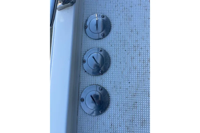 Slide: The Image of Three metal fuel caps on a 1990 Mikelson 48 Sportfisher boat deck. - 29