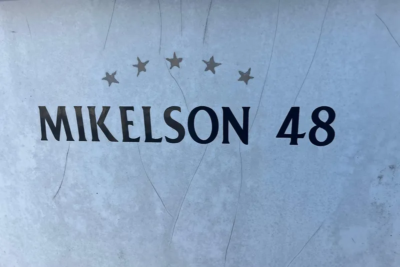 Slide: The Image of 1990 Mikelson 48 Sportfisher boat nameplate with stars on a textured surface. - 30