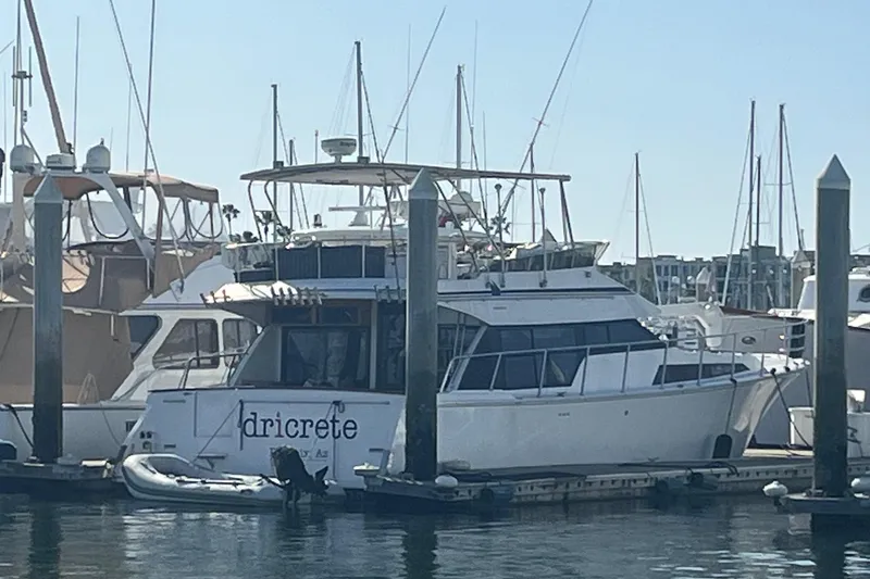 Slide: The Image of 1990 Mikelson 48 Sportfisher yacht docked at marina, surrounded by other boats. - 33