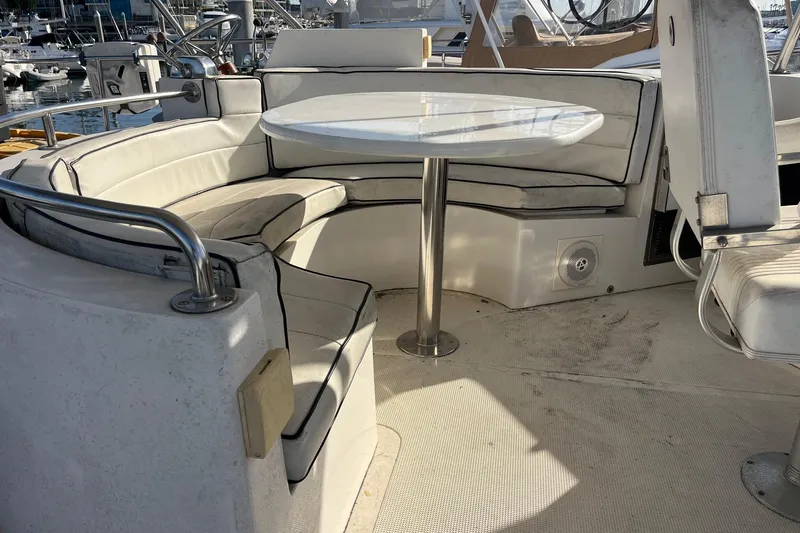 Slide: The Image of 1990 Mikelson 48 Sportfisher yacht interior with cushioned seating and round table. - 4
