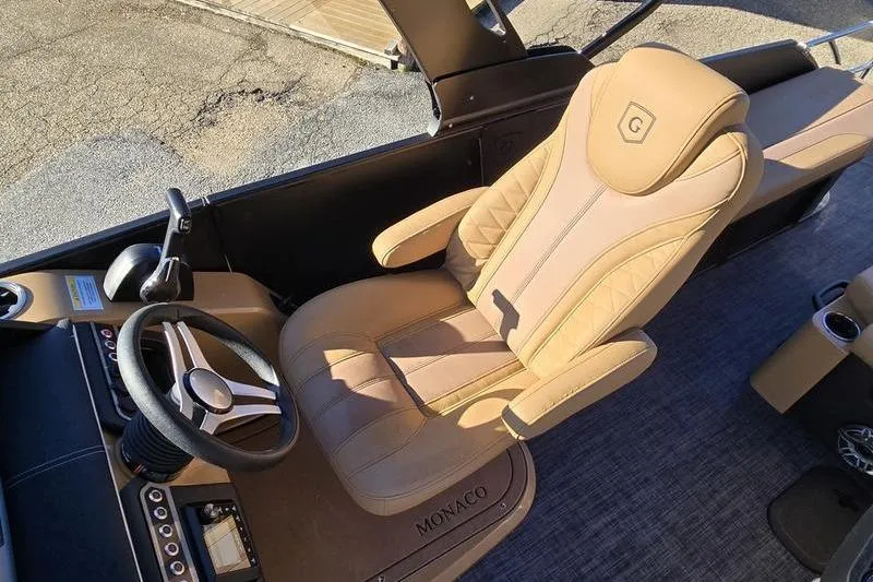 Slide: The Image of Luxurious captain's chair in 2026 Godfrey Monaco 235 SFL boat, featuring elegant design and controls. - 12