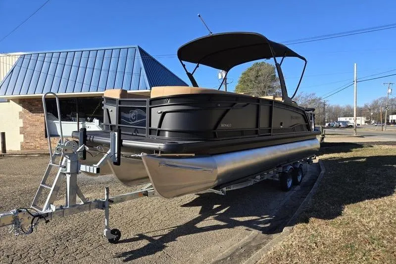 Slide: The Image of 2026 Godfrey Monaco 235 SFL pontoon boat on trailer, parked outdoors under clear blue sky. - 6
