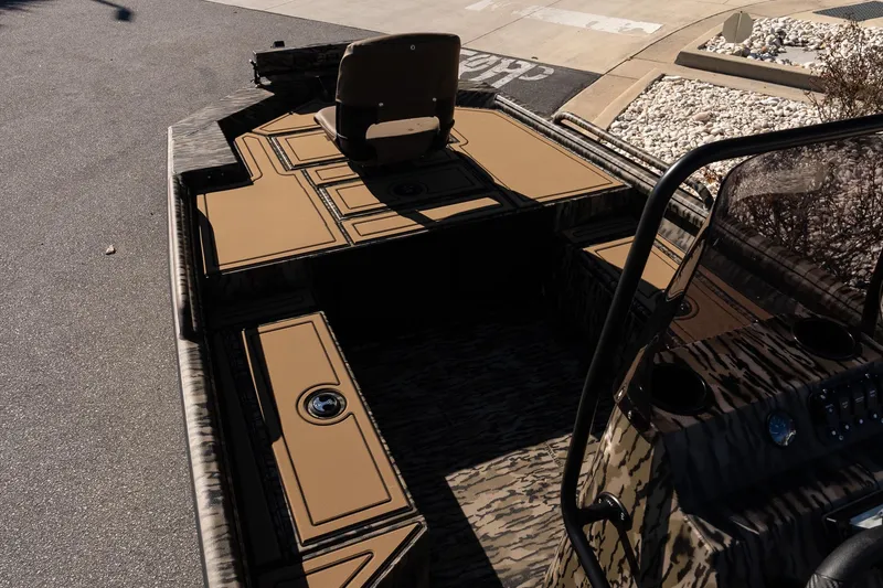 Slide: The Image of 2026 Excel 1860 Shallow Water F4 CC boat interior with camo design and seating. - 12