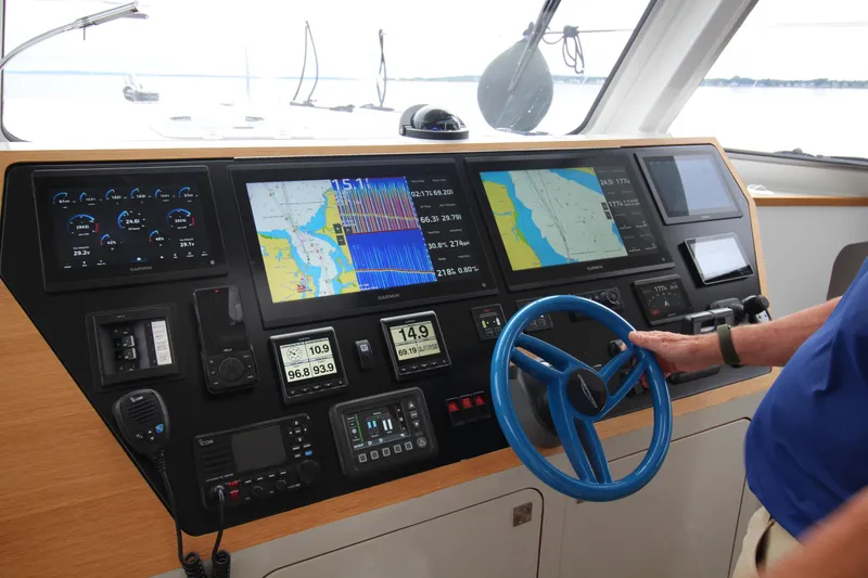 Slide: The Image of Control panel of 2026 Chris White Spindrift 47 yacht with navigation screens and steering wheel. - 3