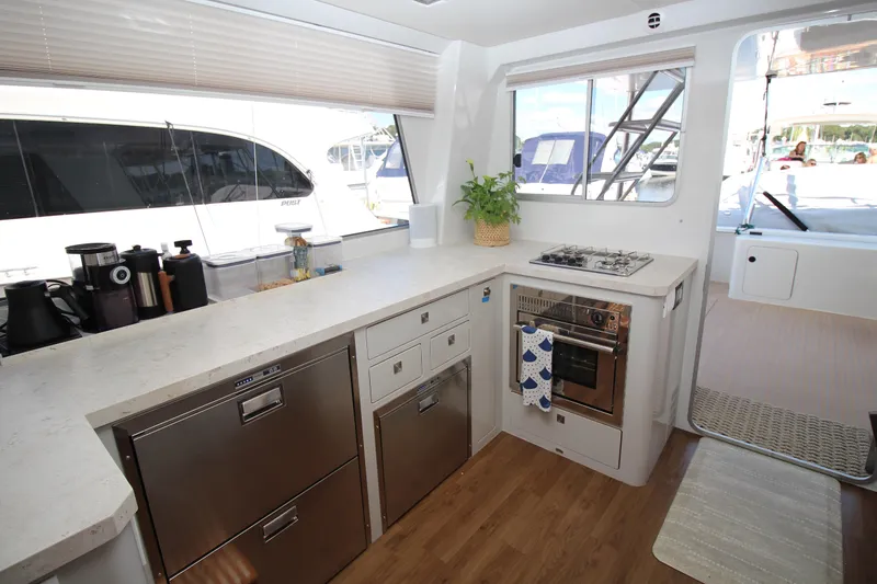 Slide: The Image of Modern kitchen interior of 2026 Chris White Spindrift 47 yacht with appliances and wooden flooring. - 5