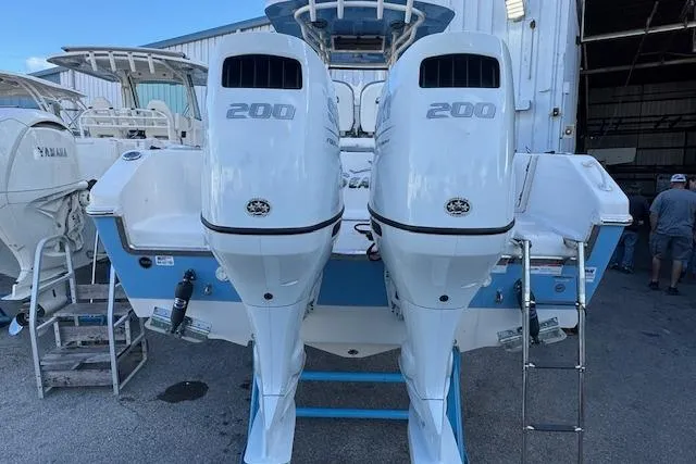 Slide: The Image of 2024 Sea Chaser 27 HFC CC boat with twin 200 horsepower engines, docked outdoors. - 3