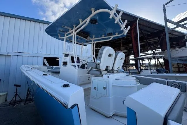 Slide: The Image of 2024 Sea Chaser 27 HFC CC boat with blue and white interior, docked in a marina. - 6