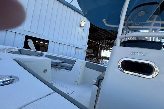 Slide: The Image of 2024 Sea Chaser 27 HFC CC boat docked near a warehouse, showcasing sleek design. - 8