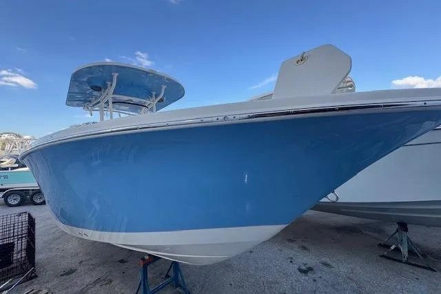 Slide: The Image of 2024 Sea Chaser 27 HFC CC boat with blue hull, docked on land. - 9