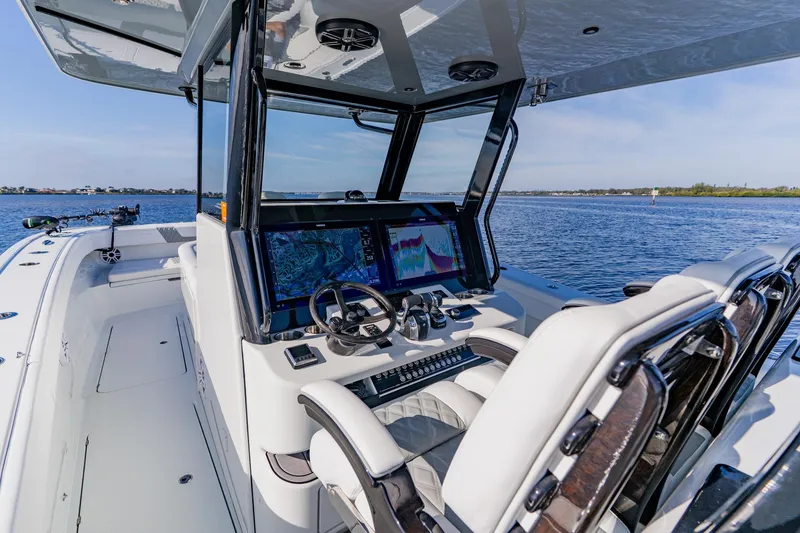 Slide: The Image of 2024 Costa Custom Boats 34SV cockpit with advanced navigation screens on a calm sea. - 15