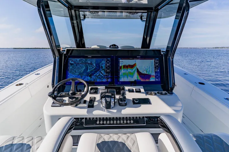 Slide: The Image of 2024 Costa Custom Boats 34SV helm with advanced navigation displays on open water. - 17