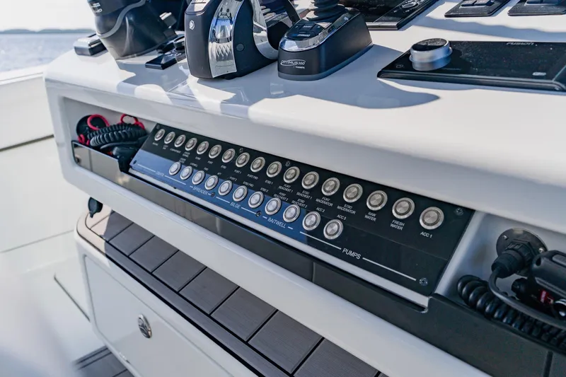 Slide: The Image of 2024 Costa Custom Boats 34SV control panel with switches and throttle levers. - 21