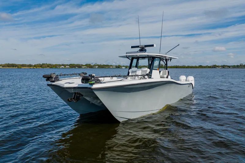 Slide: The Image of 2024 Costa Custom Boats 34SV on calm water under blue sky. - 3