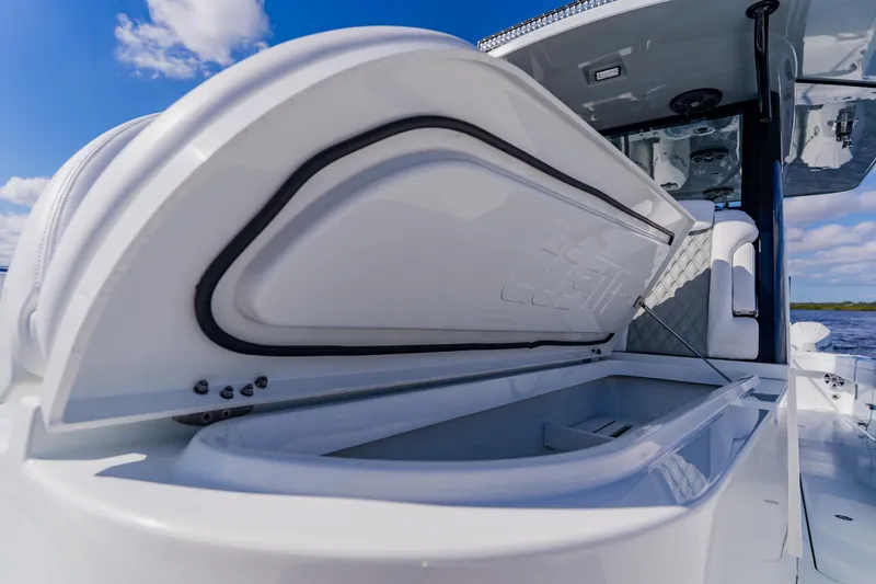 Slide: The Image of 2024 Costa Custom Boats 34SV, open storage compartment, sleek design, blue sky background. - 37