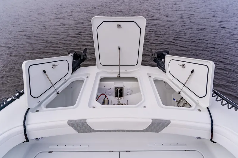 Slide: The Image of 2024 Costa Custom Boats 34SV storage compartments open on calm water. - 38