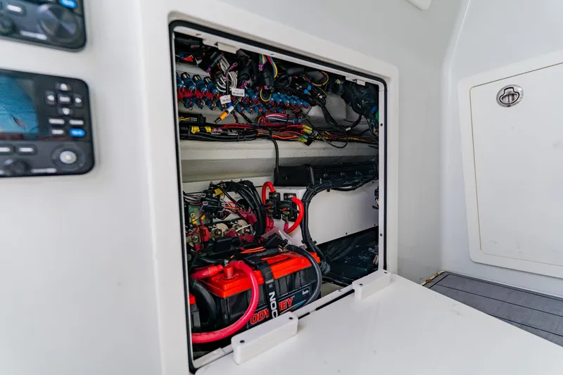 Slide: The Image of 2024 Costa Custom Boats 34SV electrical compartment with wiring and battery setup. - 48